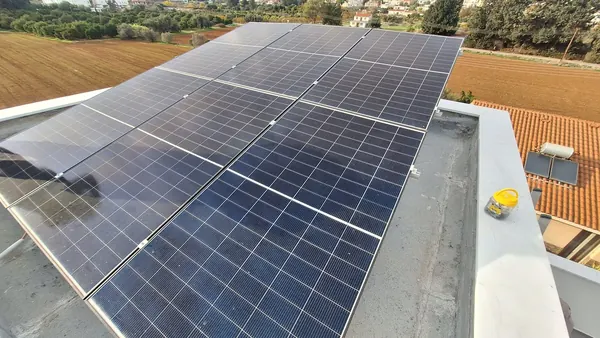 Φωτοβολταϊκό σε ταράτσα πίσω από στηθαίο, με θέα σε χωράφια, Κύπρος